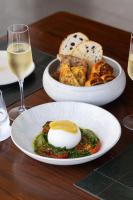 a table with two plates of food and a glass of wine at B Hotel Brasilia in Brasilia
