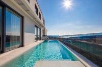 einen Infinity-Pool in einem Haus mit Fenstern in der Unterkunft www VillaGoldenHill com in Podstrana