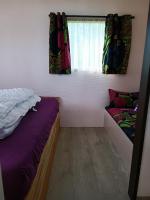 a bedroom with two beds and a window with curtains at Chabatz d entraz in Lubersac