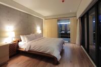a bedroom with a large bed with white sheets at Fu Wan Cafe Villa in Donggang