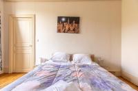 a bed in a bedroom with a picture on the wall at F3 Av république avec garage (c) in Clermont-Ferrand