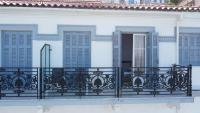 - un balcon d&#39;une maison blanche avec volets bleus dans l&#39;établissement Leonidas Hotel, à Gythio