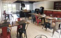 un restaurante con mesas y sillas en una habitación en Noemys ARLES, en Arles