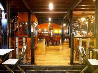 um restaurante com pisos e mesas e cadeiras de madeira em Blue Sand Beach Resort em Triquinimale