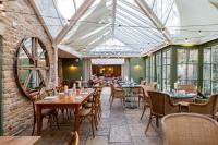 奥克姆The Barnsdale, Rutland的餐厅设有桌椅和玻璃天花板