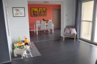 a living room with a dog and a table and chairs at Panorama Apartman in Velence