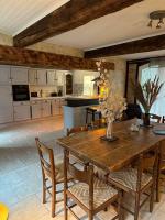 a large kitchen with a wooden table and chairs at Gite l’Oasis in Astaffort