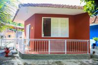 a small red house with a white balcony at Pousada Mama África in Conservatória