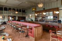 a dining room with tables and a bar at Cliftonville Hotel in Cromer