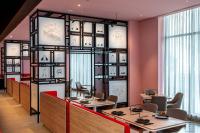 ein Restaurant mit Tischen und Stühlen und einer Wand mit Uhren in der Unterkunft Beach Walk Hotel Jumeirah in Dubai