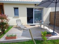 a wooden deck with two chairs and an umbrella at C La Belle Vie in Pessac