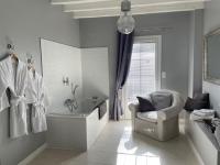 ein Bad mit einer Badewanne, einem Stuhl und einem Fenster in der Unterkunft GITE ROMANTIQUE in Cléré-les-Pins