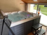 eine Whirlpool-Badewanne in einem Haus mit Bank in der Unterkunft GITE ROMANTIQUE in Cléré-les-Pins