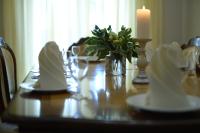 Borovik في Novosilki: طاولة عليها شمعة ومناديل بيضاء ومزهرية من الزهور