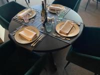 een zwarte tafel met borden en servetten erop bij De Post B&B Restaurant in Klimmen