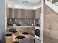 a kitchen with a wooden table with chairs and appliances at Jasmine loft luxury 1 in Kokkini Khanion