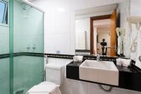 a bathroom with a sink and a toilet and a mirror at Hotel Santorini in Vila Velha