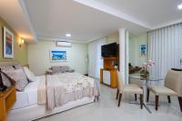 a bedroom with a bed and a table and a television at Hotel Santorini in Vila Velha