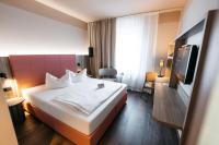 a hotel room with a bed and a tv at City Park Hotel in Frankfurt Oder