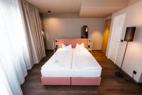 a bedroom with a bed with a pink and white mattress at City Park Hotel in Frankfurt Oder