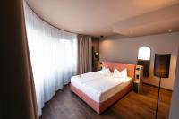 a bedroom with a bed and a large window at City Park Hotel in Frankfurt Oder