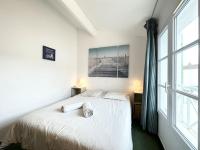 a bedroom with a white bed and a large window at La Voile Bleue de La Flotte in La Flotte