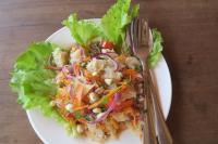 un'insalata su un piatto bianco con forchetta e coltello di Samaki Guesthouse & Grandpa Homestay- Tad Lo a Ban Donkhagnoung