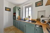 eine Küche mit grünen Schränken, einem Waschbecken und einem Fenster in der Unterkunft Maison Chandolas - Charmante maison pour 10 voyageurs in Chandolas