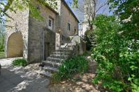 ein altes Steingebäude mit einer Treppe und einem Tor in der Unterkunft Maison Chandolas - Charmante maison pour 10 voyageurs in Chandolas