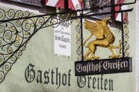 Un cartel de un restaurante con un caballo en un edificio. en Hotel-Gasthof Goldener Greifen, en Rothenburg ob der Tauber