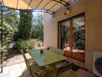 a green table and chairs on a patio at Holiday Home Chez Béatrice et Pascal by Interhome in Belgodère