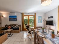 a living room with a dining table and a couch at Holiday Home Chez Béatrice et Pascal by Interhome in Belgodère