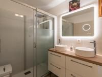 a bathroom with two sinks and a glass shower at Holiday Home Chez Béatrice et Pascal by Interhome in Belgodère