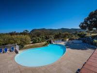 a swimming pool with chairs and a view of the mountains at Holiday Home Chez Béatrice et Pascal by Interhome in Belgodère