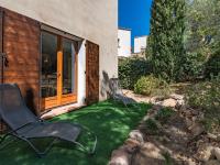 two chairs sitting on a lawn in front of a house at Holiday Home Chez Béatrice et Pascal by Interhome in Belgodère