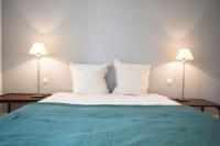 a bedroom with a bed with white pillows and two lamps at L&#39;appartement du Cellier in Pommard