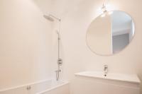 a white bathroom with a sink and a mirror at L&#39;appartement du Cellier in Pommard