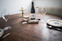 a bottle of wine sitting on a wooden table with glasses at L&#39;appartement du Cellier in Pommard