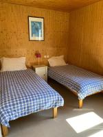 a room with two beds in a wooden room at Beautiful lake view 3 bedroom chalet. in Saint-Manvieu-Bocage