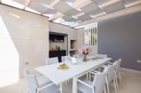 ein Esszimmer mit einem weißen Tisch und weißen Stühlen in der Unterkunft www VillaGoldenHill com in Podstrana