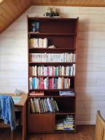 a book shelf filled with books next to a desk at Kerletty, la mer, les embruns, à 250 m des plages in Plouguerneau