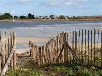 a wooden fence on the beach near the water at Kerletty, la mer, les embruns, à 250 m des plages in Plouguerneau