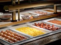 a buffet line with eggs and other food on trays at Pinia Hotel & Resort in Špindlerův Mlýn