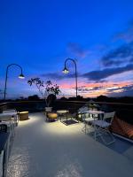 una terraza con mesas, sillas y una puesta de sol en Cendhani Raras Gallery, en Kejayan