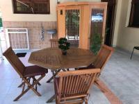 a wooden table and chairs in a room at Villa Red Palmer -sauna jacuzzi in Gros-Morne