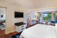 a hotel room with a bed and a television at Sheraton Samui Resort in Chaweng Noi Beach
