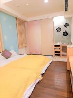 a bedroom with a large bed with a yellow blanket at 水社海民宿 in Yuchi