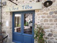 DésaignesにあるLAne Têtuの石造りの建物に看板の付いた青いドア