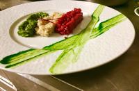 ein Teller mit Essen und Gemüse auf einem Tisch in der Unterkunft Logis Hotel Restaurant Le Grand Puech in Mimet