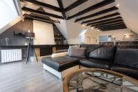 ein Wohnzimmer mit einem Ledersofa und einem Tisch in der Unterkunft - L&#39;Observatoire - Vue - Centre- Atypique in Rodez